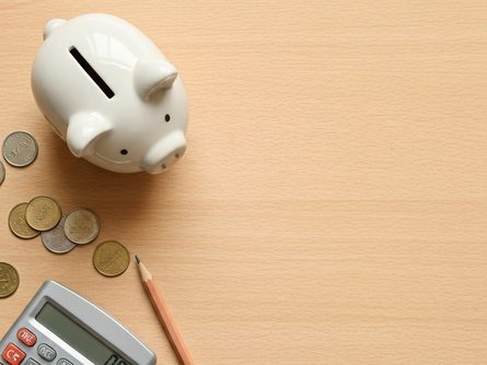 저금통과 계산기가 놓인 책상